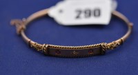 Lot 290 - A ruby and diamond set 9ct. yellow gold bangle,...