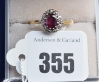 Lot 355 - A ruby and diamond cluster ring on yellow...