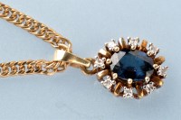 Lot 391 - A sapphire and diamond pendant, the oval facet...