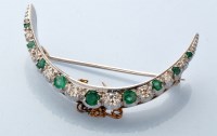Lot 825 - A diamond and emerald crescent pattern brooch,...