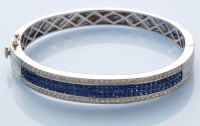 Lot 1029 - A sapphire and diamond bangle, the three rows...