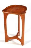 Lot 14 - A teak stool, the shaped seat on triform legs,...
