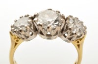 Lot 928 - A three stone diamond ring, the central...