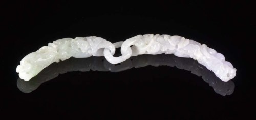 Lot 45 - A carved jadeite pendant, the stone of pale...