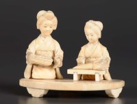 Lot 77 - A carved ivory group of two women kneeling...
