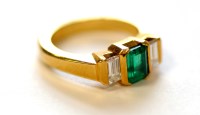 Lot 732 - An emerald and diamond ring, the baguette cut...