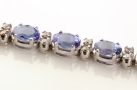 Lot 702 - A tanzanite and diamond line bracelet, each of...