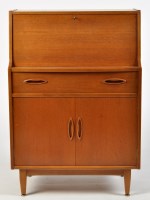 Lot 1157 - A teak bureau, the fall-flap enclosing a...