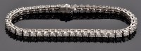Lot 948 - A diamond tennis bracelet, set with forty-five...