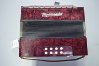 Lot 1567 - A Worldmaster small accordion, in red plastic...