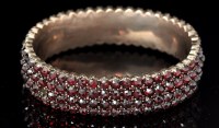Lot 551 - A Victorian garnet bangle, the rose cut...