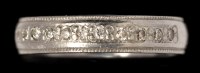 Lot 599 - A diamond wedding band, half set with...