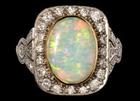 Lot 696 - An opal and diamond dress ring, the oval opal...