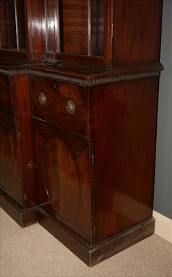 Lot 1226 - A George III mahogany breakfront secretaire bookcase.