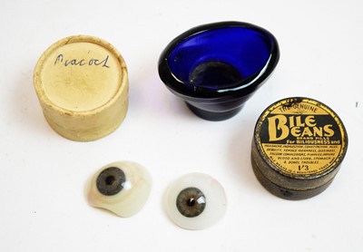 Lot 797 - Two glass eyes and an eye bath
