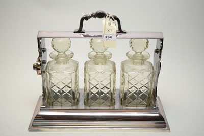 Lot 284 - Silver-plated tantalus and four spirit decanters and stoppers.