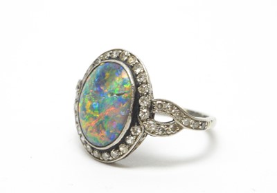 Lot 54 - A black opal and diamond cluster ring.