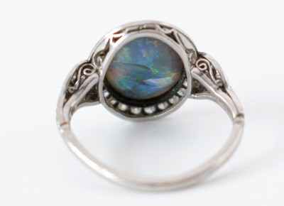 Lot 54 - A black opal and diamond cluster ring.