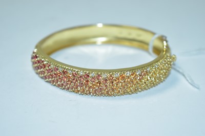 Lot 203 - A gem set yellow metal bangle