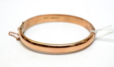 Lot 119 - A 9ct gold hinged bangle.