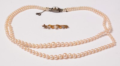 Lot 223 - An early 20th Century diamond, pearl, and yellow-metal bar brooch.