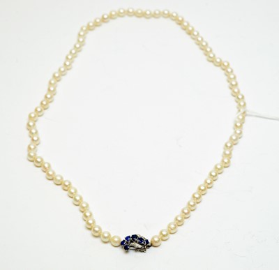 Lot 125 - A pearl necklace with high-carat white metal, diamond, and sapphire clasp.