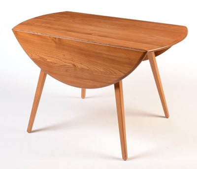 Lot 56 - Ercol: a light beech and elm round-shaped drop-leaf dining table.