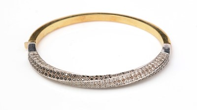 Lot 499 - A diamond and black diamond bangle