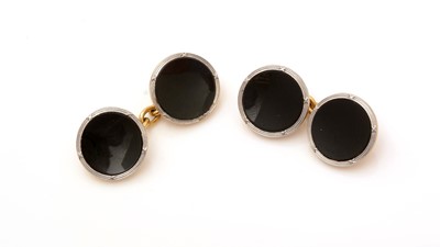 Lot 500 - A pair of onyx set button pattern cufflinks