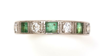 Lot 350 - An emerald and diamond half-hoop eternity ring
