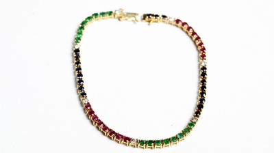 Lot 501 - A diamond, ruby, sapphire and emerald tennis bracelet