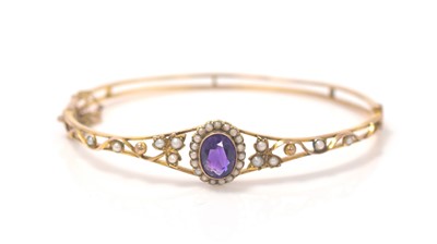 Lot 352 - An Edwardian amethyst and seed pearl bangle