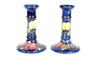 Lot 689 - A matched pair of Moorcroft Wisteria pattern candlesticks