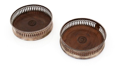 Lot 195 - Two similar George III silver-mounted wine coasters.