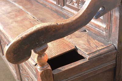 Lot 1104 - A North Country joined and carved oak box settle.