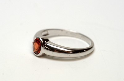 Lot 216 - An orange sapphire ring