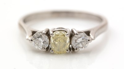 Lot 411 - Three stone yellow and white diamond ring