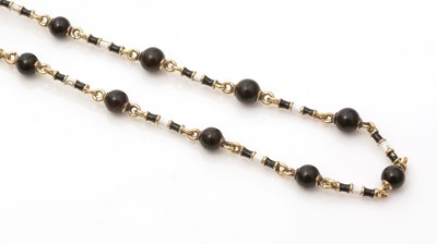 Lot 662 - An onyx, enamel and gold muff chain necklace