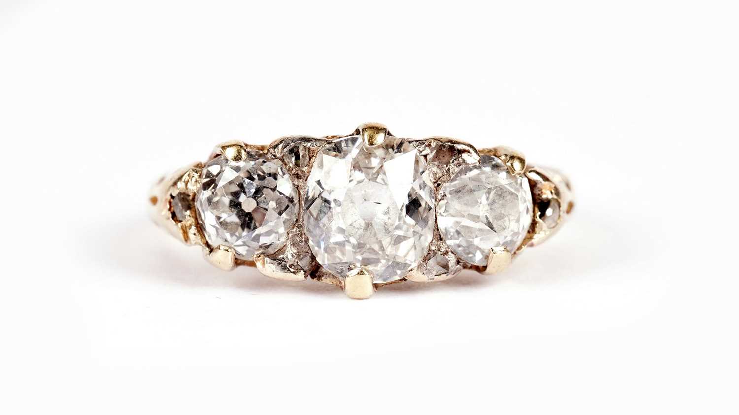 Lot 1129 - A Victorian three stone old-cut diamond ring
