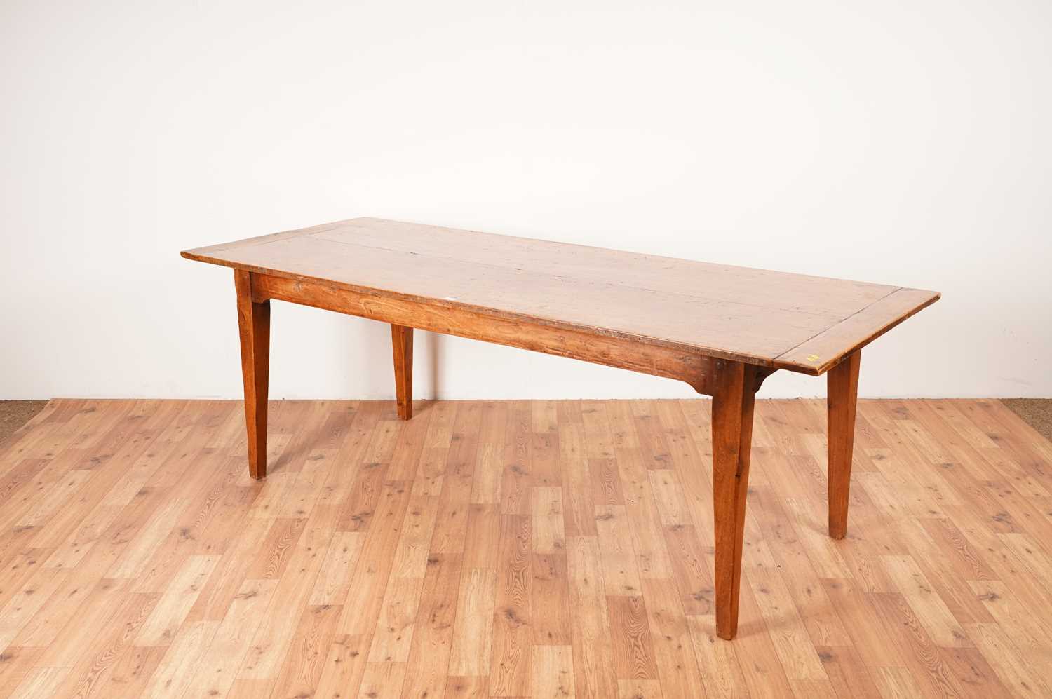 Lot 17 - A rustic French fruitwood refectory dining table