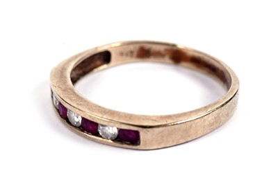 Lot 585 - A ruby and diamond half hoop eternity ring