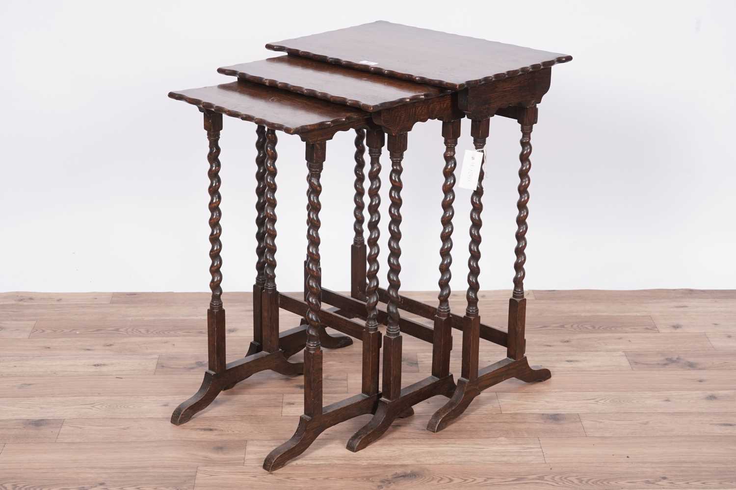 Lot 27 - An early 20th Century oak nest of three tables