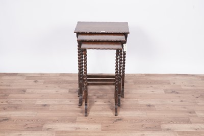 Lot 27 - An early 20th Century oak nest of three tables