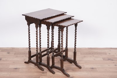 Lot 27 - An early 20th Century oak nest of three tables