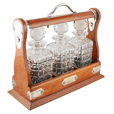 Lot 323 - An early 20th Century oak three-decanter tantalus