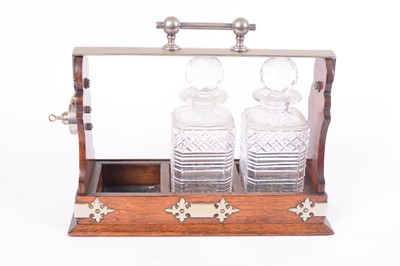 Lot 424 - An early 20th Century oak tantalus