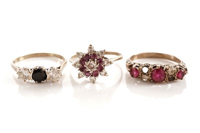 Lot 93 - A sapphire and white stone ring; and two red and white stone rings