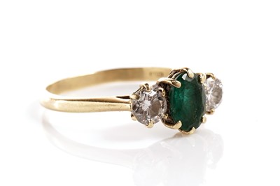 Lot 175 - An emerald and diamond three stone ring