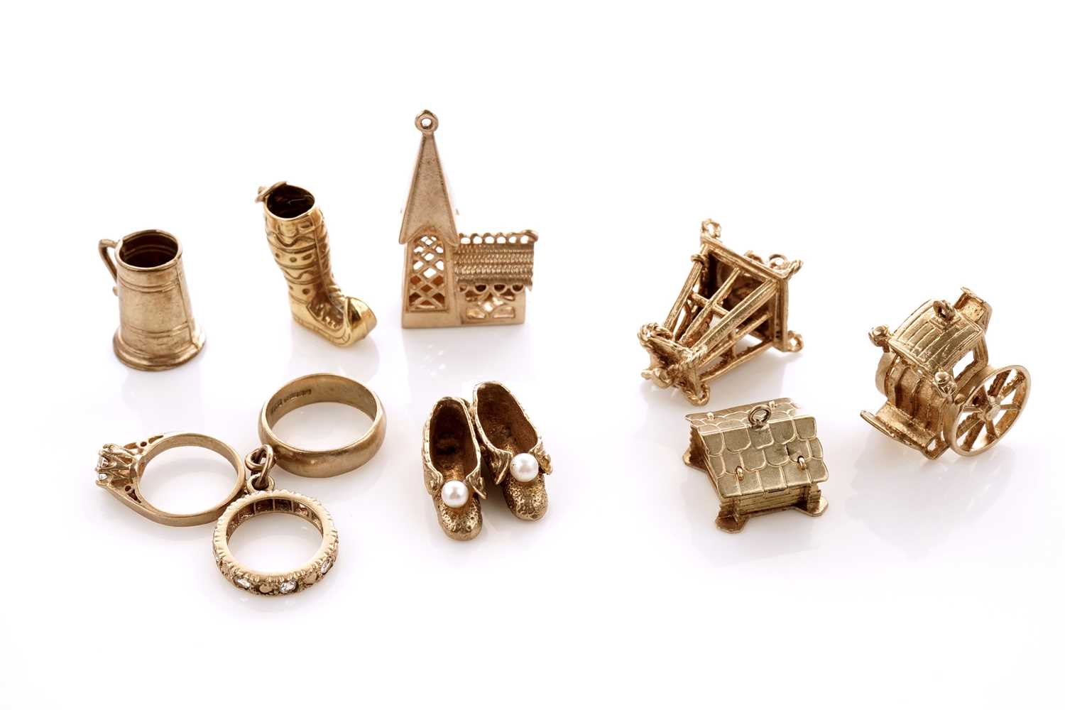 Lot 20 - A collection of 9ct yellow gold charms; with a gilt metal charm