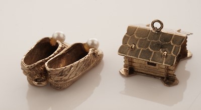 Lot 20 - A collection of 9ct yellow gold charms; with a gilt metal charm